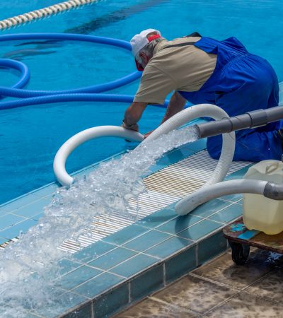 cleaning the sports pool with a cleaning water pump. the water pump filters the water from the bottom of the pool, cleans from dirt and debris. the cleaning pump works with the pool.